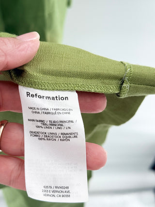 Reformation malibu linen midi dress crafted from lightweight linen, designed with structured sweetheart bodice and subtle front cutout connected by center bar detail, 2