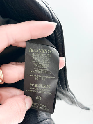 Blank NYC faux leather moto jacket featuring asymmetrical zip-front closure, oversized lapels, zippered pockets, XS