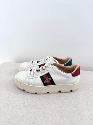Gucci Ace platform sneakers crafted in smooth leather with iconic green and red web stripe and embroidered gold bee detail, finished with metallic heel tabs, and chunky platform rubber sole, 38.5