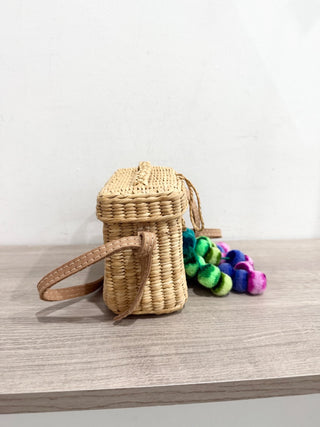 Nannacay small straw bag with pom pom charms and long strap
