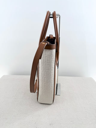 Balmain logo tote bag crafted from jacquard canvas featuring signature tonal monogram pattern, accented with smooth cognac leather trim, dual rolled top handles and detachable shoulder strap