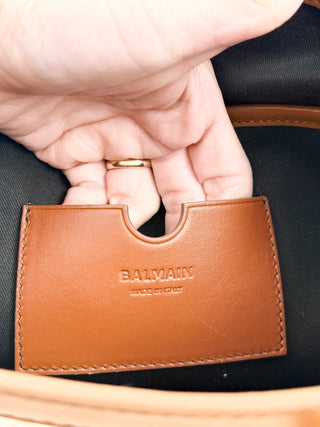 Balmain logo tote bag crafted from jacquard canvas featuring signature tonal monogram pattern, accented with smooth cognac leather trim, dual rolled top handles and detachable shoulder strap