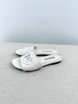 Dolce and Gabbana leather slide sandals featuring signature cutout DG logo across the vamp, 32