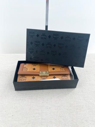 MCM long wallet crafted in iconic cognac visetos coated canvas with logo print and smooth leather accents