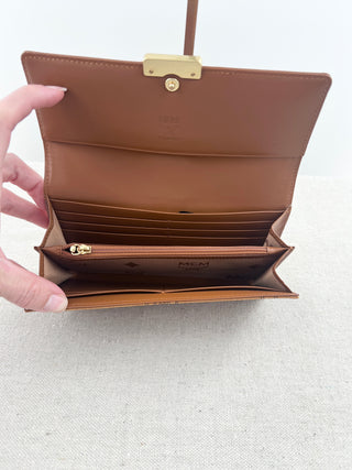 MCM long wallet crafted in iconic cognac visetos coated canvas with logo print and smooth leather accents