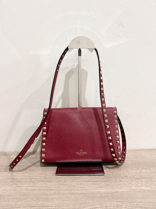 Valentino Garavani Pebbled Calfskin Medium Rockstud Flip Lock Crossbody Bag burgundy
