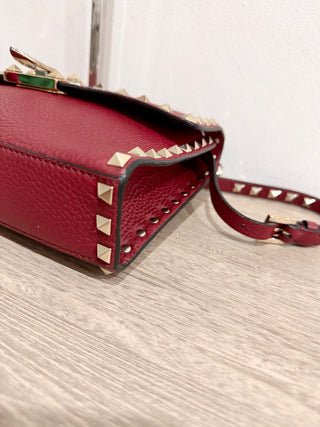 Valentino Garavani Pebbled Calfskin Medium Rockstud Flip Lock Crossbody Bag burgundy