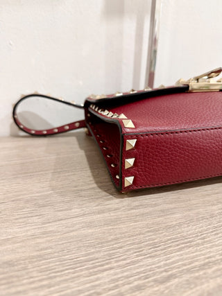 Valentino Garavani Pebbled Calfskin Medium Rockstud Flip Lock Crossbody Bag burgundy