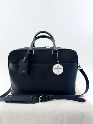Louis Vuitton briefcase crafted in signature taiga leather featuring top zip closure, front slip pocket, and rolled leather handles