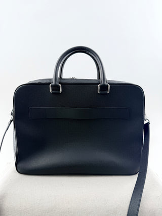 Louis Vuitton briefcase crafted in signature taiga leather featuring top zip closure, front slip pocket, and rolled leather handles