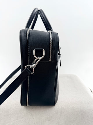 Louis Vuitton briefcase crafted in signature taiga leather featuring top zip closure, front slip pocket, and rolled leather handles
