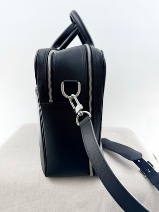Louis Vuitton briefcase crafted in signature taiga leather featuring top zip closure, front slip pocket, and rolled leather handles