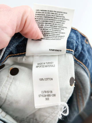 Agolde high-rise denim shorts featuring vintage wash, distressed detailing, and frayed raw hem, 27